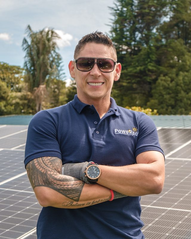Especialista de PoweRoof frente a un arreglo de paneles solares instalados en un techo