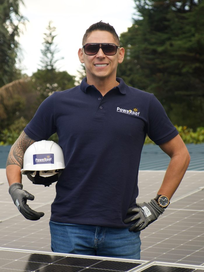 Especialista de PoweRoof con casco de seguridad sobre un techo cubierto de paneles solares