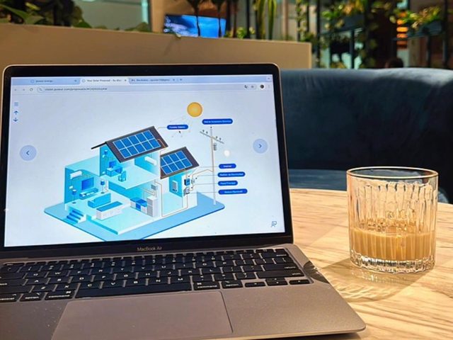 Portátil mostrando el esquema de una vivienda con paneles solares durante el análisis